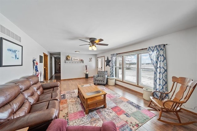 living room with visible vents, baseboards, ceiling fan, and wood finished floors