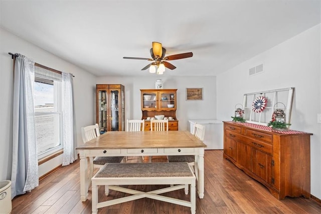 dining room featuring visible vents, baseboards, ceiling fan, and hardwood / wood-style flooring