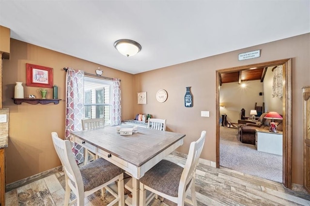 dining room featuring light wood-type flooring and baseboards