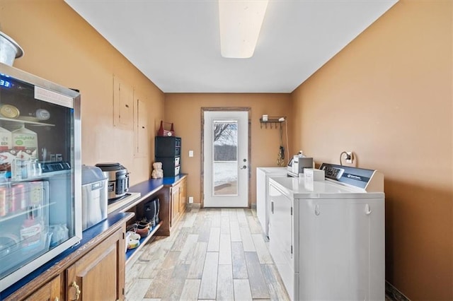 laundry area featuring laundry area, washer and dryer, and light wood-style floors