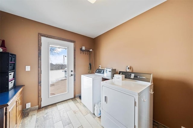 clothes washing area featuring light wood-style floors and washing machine and clothes dryer