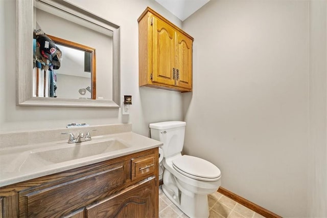 half bath featuring vanity, tile patterned floors, toilet, and baseboards