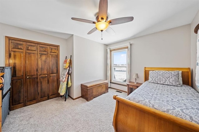 bedroom featuring visible vents, light colored carpet, baseboards, and a ceiling fan