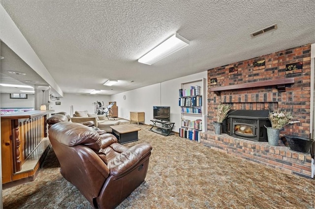 living room with a wood stove, carpet flooring, visible vents, and a textured ceiling