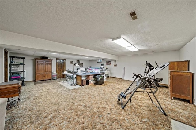 recreation room with visible vents, light colored carpet, and a textured ceiling