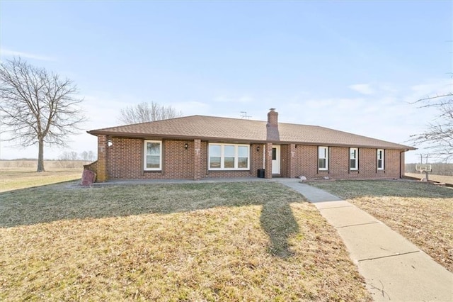 ranch-style home featuring a front yard, brick siding, and a chimney