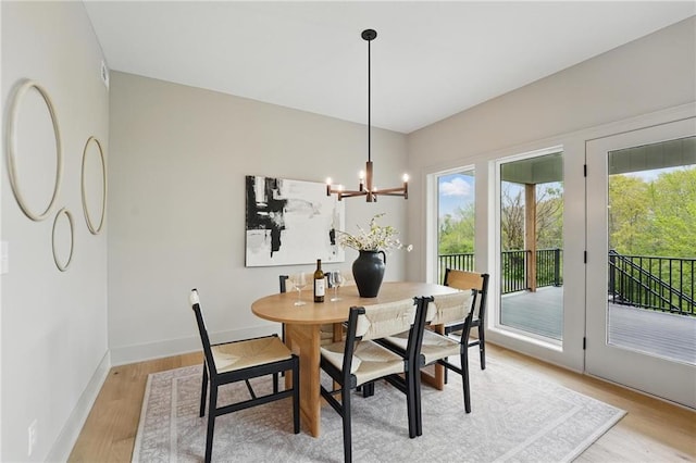 1506 NW 106th Ter, Kansas City, MO 64155 - dining room featuring a healthy amount of sunlight, baseboards, light wood finished floors, and a chandelier