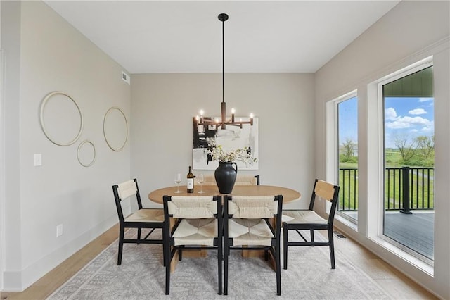 1506 NW 106th Ter, Kansas City, MO 64155 - dining space with baseboards, visible vents, light wood finished floors, and a notable chandelier