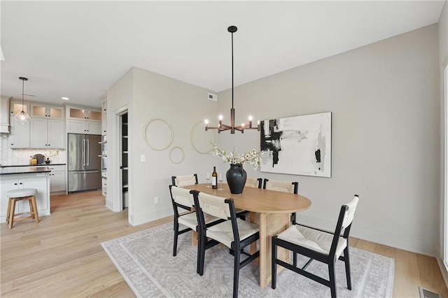1506 NW 106th Ter, Kansas City, MO 64155 - dining area with baseboards, a notable chandelier, light wood-style flooring, and visible vents