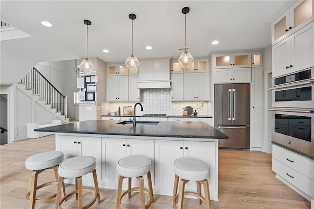 1506 NW 106th Ter, Kansas City, MO 64155 - kitchen featuring stainless steel appliances, dark countertops, a sink, and premium range hood