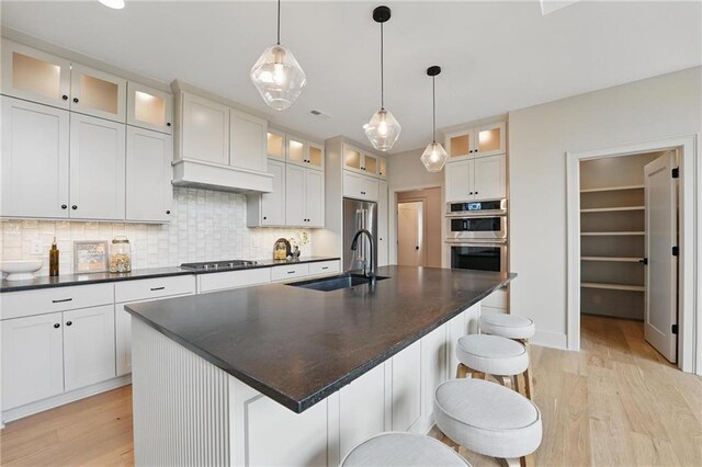 1506 NW 106th Ter, Kansas City, MO 64155 - kitchen featuring a sink, light wood finished floors, stainless steel double oven, and dark countertops