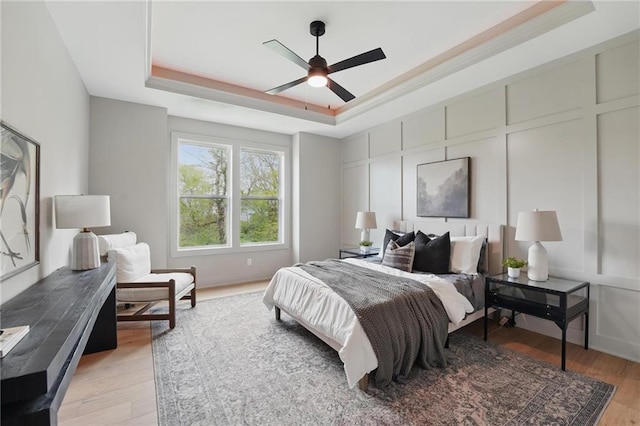 1506 NW 106th Ter, Kansas City, MO 64155 - bedroom with ceiling fan, light wood finished floors, a raised ceiling, a decorative wall, and ornamental molding