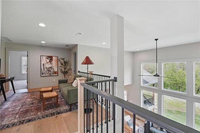 1506 NW 106th Ter, Kansas City, MO 64155 - hallway featuring visible vents, recessed lighting, wood finished floors, and an upstairs landing