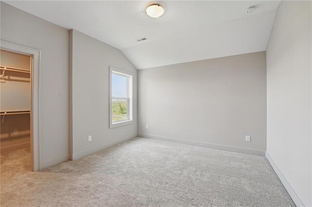 1506 NW 106th Ter, Kansas City, MO 64155 - unfurnished bedroom with a spacious closet, vaulted ceiling, carpet floors, and visible vents
