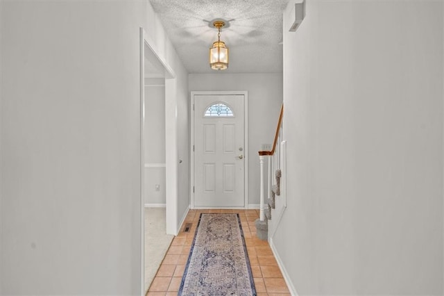 doorway to outside featuring stairway, baseboards, a textured ceiling, and light tile patterned flooring