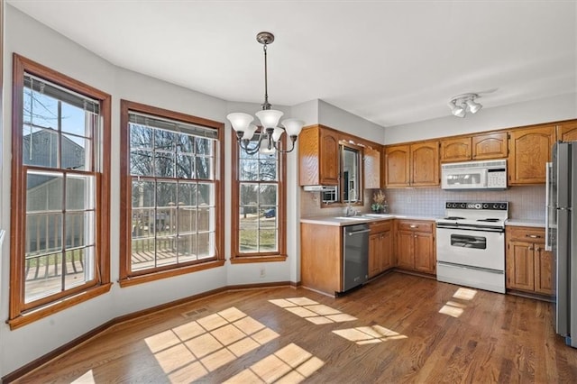 kitchen featuring light countertops, a wealth of natural light, dark wood-type flooring, and appliances with stainless steel finishes