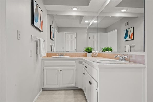 full bath featuring decorative backsplash, double vanity, visible vents, and a sink