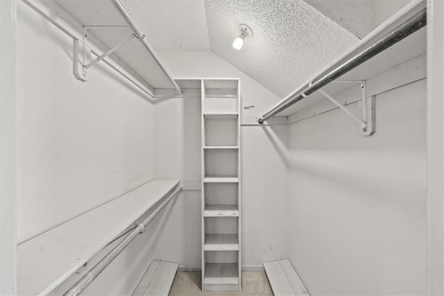 walk in closet with lofted ceiling