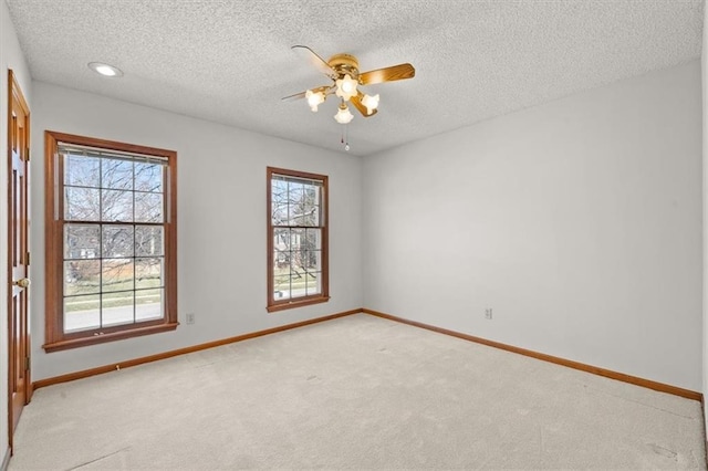 unfurnished room featuring a wealth of natural light, baseboards, and light carpet