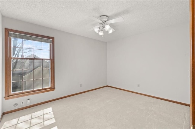 unfurnished room featuring light carpet, a textured ceiling, baseboards, and ceiling fan