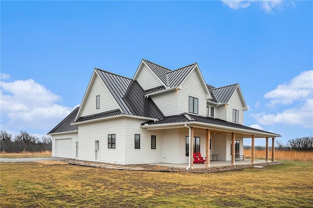 view of front of property featuring metal roof, a standing seam roof, a patio area, and a front yard