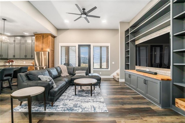 living area with recessed lighting, dark wood-style flooring, a ceiling fan, baseboards, and stairs