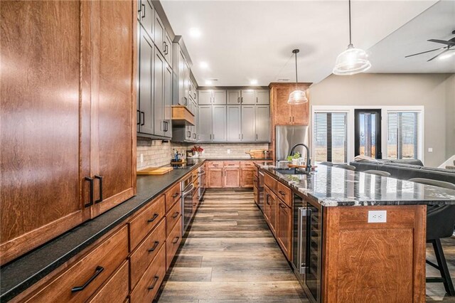 kitchen featuring decorative backsplash, a breakfast bar, dark wood-style flooring, open floor plan, and a sink