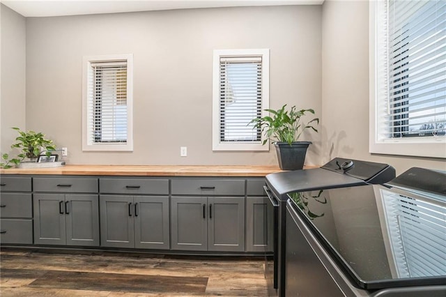 kitchen with a wealth of natural light, butcher block counters, gray cabinetry, and separate washer and dryer