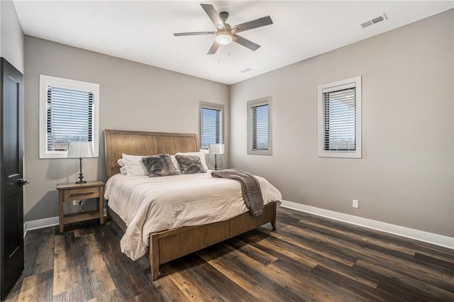 bedroom featuring a ceiling fan, baseboards, visible vents, and wood finished floors