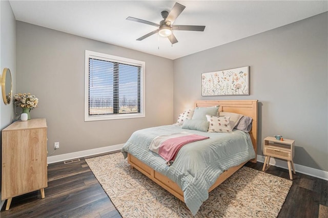 bedroom with ceiling fan, baseboards, and dark wood-style flooring