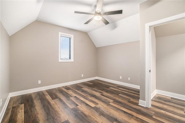 additional living space with a ceiling fan, baseboards, vaulted ceiling, and dark wood-style flooring