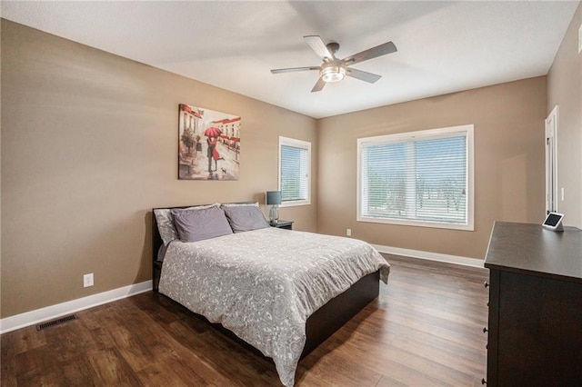 bedroom featuring dark wood-style floors, visible vents, and baseboards