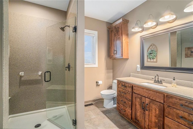 full bathroom with a stall shower, baseboards, vanity, and toilet