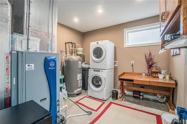 laundry area with laundry area, stacked washer / dryer, and electric water heater