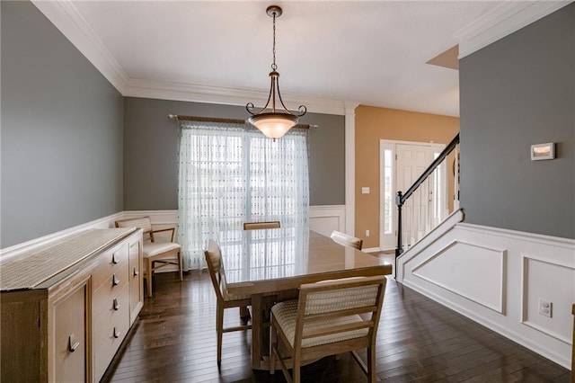 dining area featuring dark wood-style floors, a wainscoted wall, ornamental molding, stairs, and a decorative wall