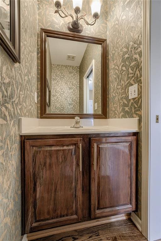 bathroom featuring vanity and wallpapered walls