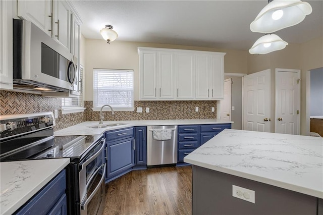 kitchen featuring blue cabinets, a sink, dark wood finished floors, stainless steel appliances, and white cabinets