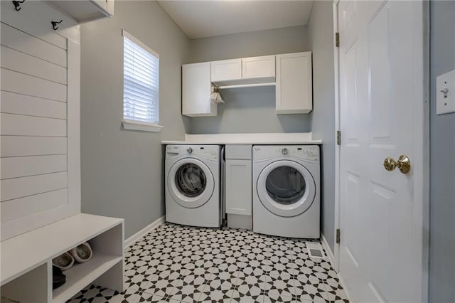 washroom featuring washer and clothes dryer, light floors, cabinet space, and baseboards