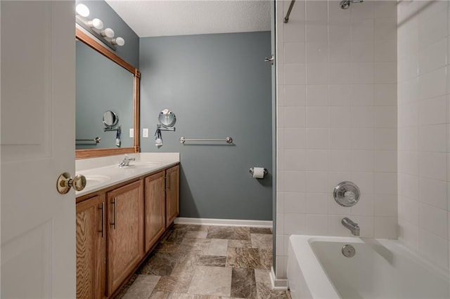 bathroom featuring baseboards, shower / tub combination, double vanity, a textured ceiling, and a sink