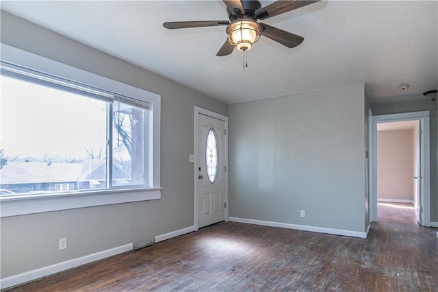 foyer with baseboards, wood-type flooring, a textured ceiling, and a ceiling fan