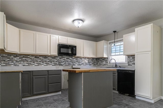 kitchen with butcher block countertops, black appliances, decorative light fixtures, a sink, and decorative backsplash