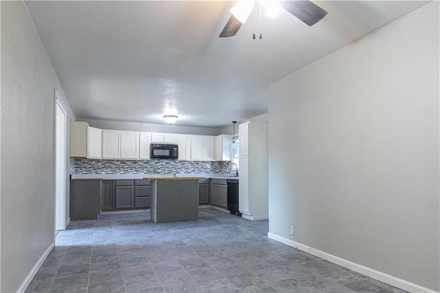 kitchen with black appliances, a ceiling fan, tasteful backsplash, and a center island