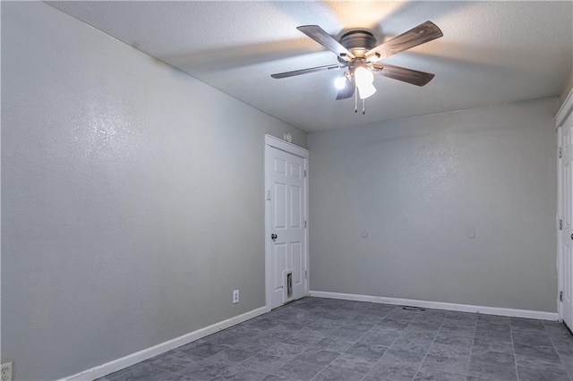 spare room featuring baseboards, a textured ceiling, and ceiling fan