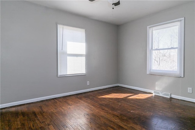 unfurnished room featuring visible vents, baseboards, ceiling fan, and hardwood / wood-style flooring