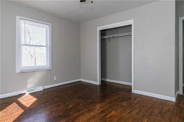 unfurnished bedroom featuring visible vents, baseboards, and hardwood / wood-style floors