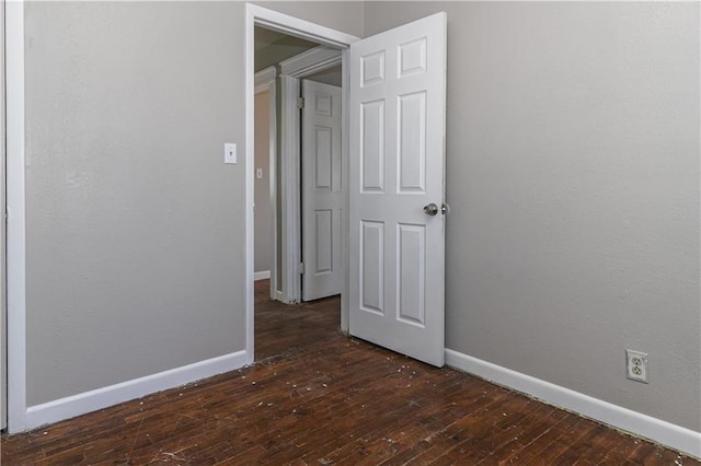 unfurnished bedroom featuring hardwood / wood-style flooring and baseboards