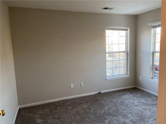 carpeted empty room featuring visible vents and baseboards