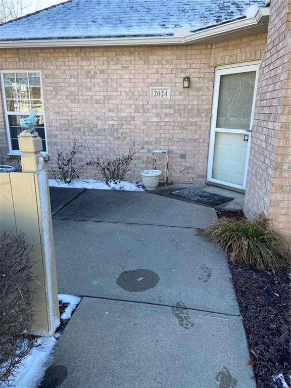 entrance to property featuring brick siding