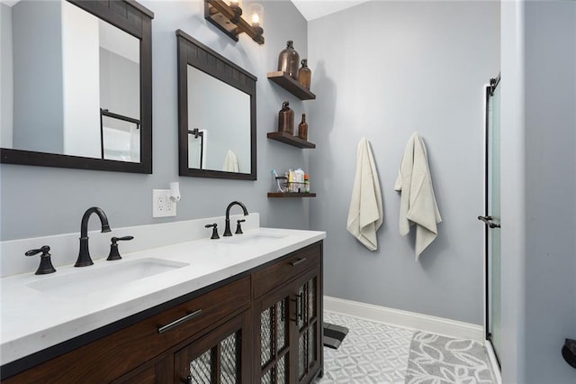 bathroom with double vanity, a sink, and baseboards