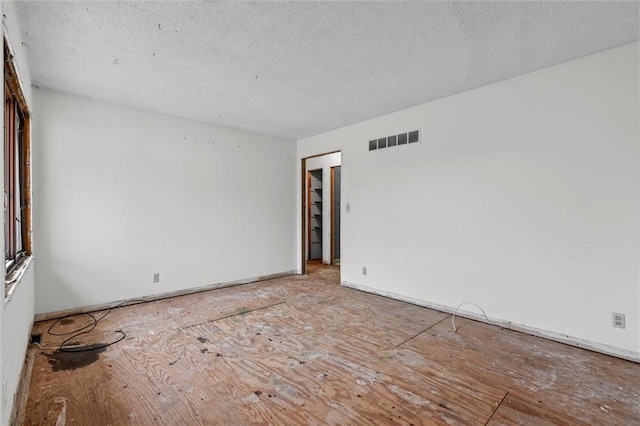 unfurnished room with visible vents and a textured ceiling